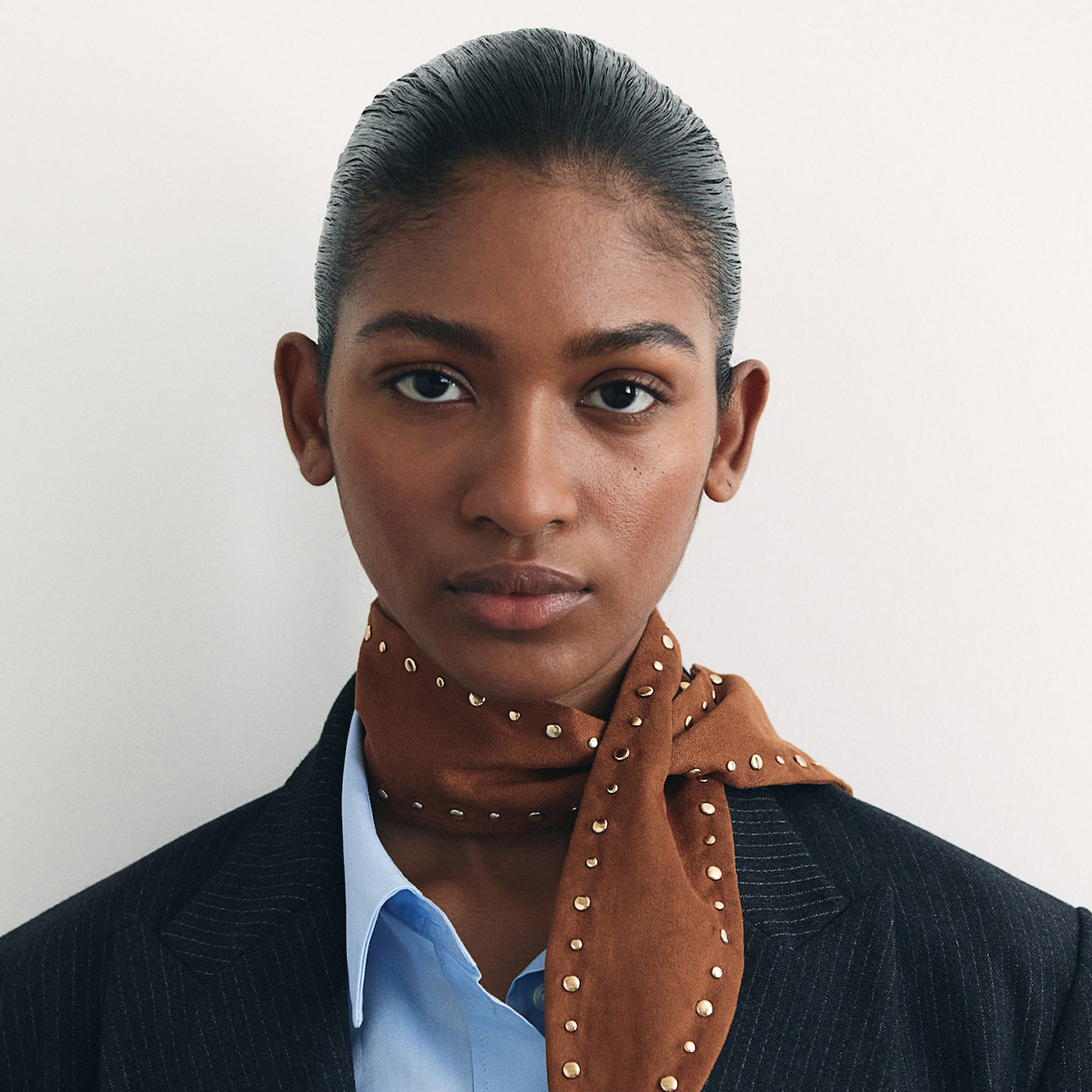 H&M model wears studded scarf in campaign photo.