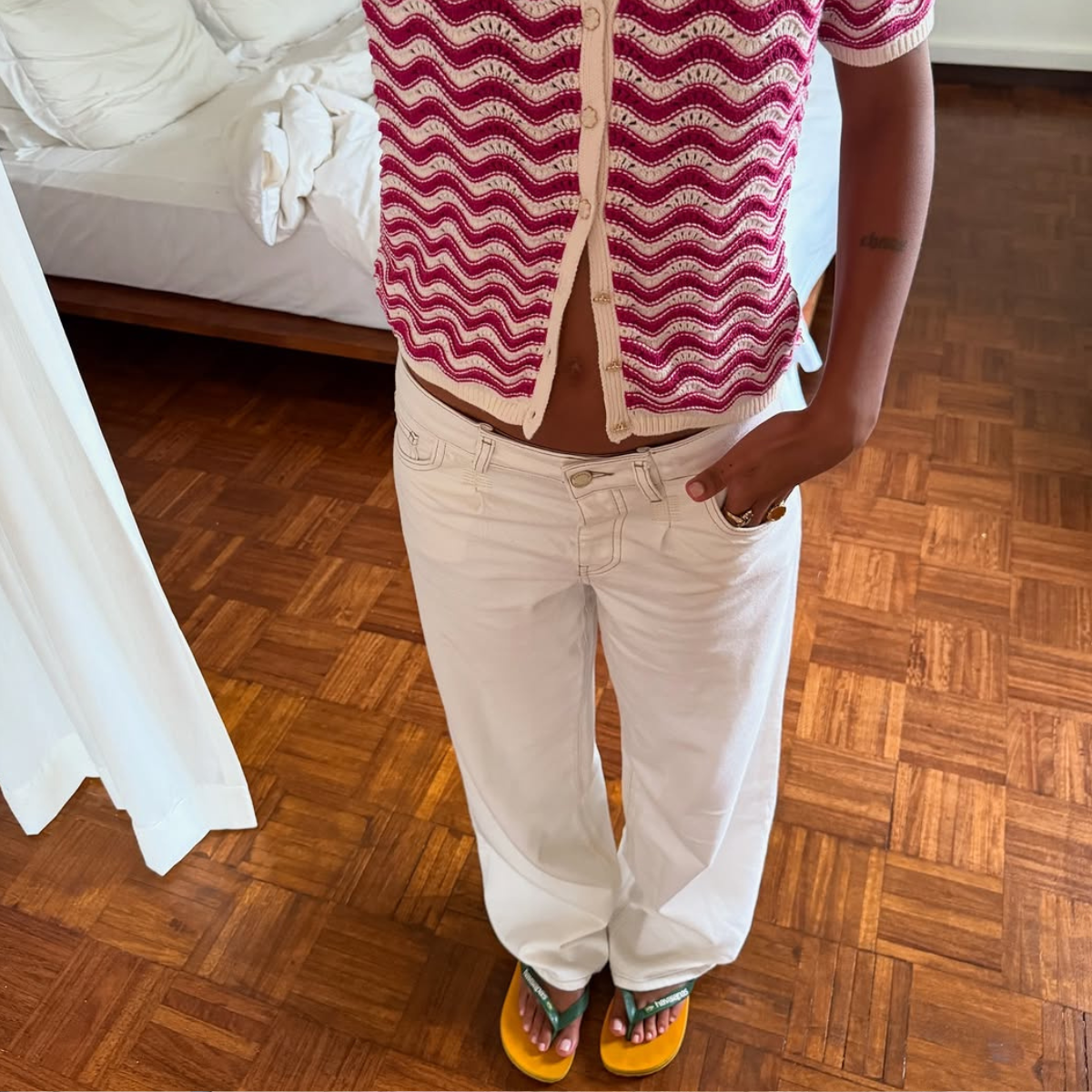 woman wearing square-toe flip flops with white jeans